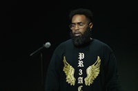 a black man with a beard and a microphone