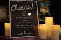 a chalkboard with a drink menu and candles next to it