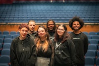 a group of people posing for a photo in an auditorium