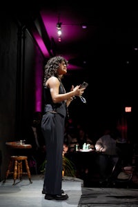 a woman standing on stage with a microphone