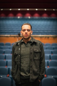a man standing in an auditorium with empty seats