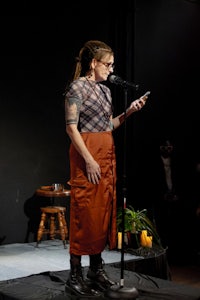 a woman standing on stage with a cell phone