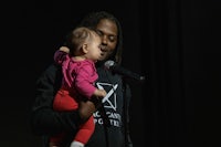 a man holding a baby in front of a microphone