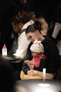 a woman holding a baby at a table in a restaurant