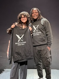 two people posing for a photo with a black hoodie